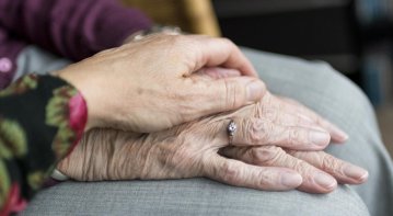 Elderly person receiving professional emotional support, sitting with a counselor in a warm, comforting environment to enhance emotional well-being.