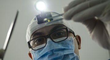 A dentist demonstrates the placement of a dental implant model to explain its role in restoring oral health.  