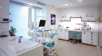 A comprehensive guidebook, dental tools, and a smiling patient in a dental clinic, representing tips for choosing the right dental care services.