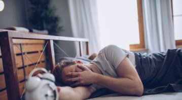 Stressed employee sitting at a desk, overwhelmed with work