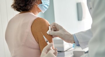 Elderly patient receiving pneumonia vaccine from a healthcare professional as part of preventive senior care