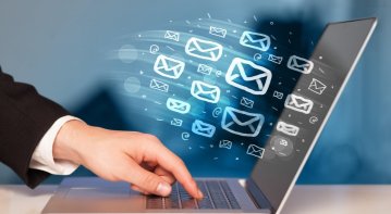 A marketer designs vibrant digital banners on a laptop, showcasing brand logos, bold headlines, and call-to-action buttons to enhance a marketing campaign’s online impact.