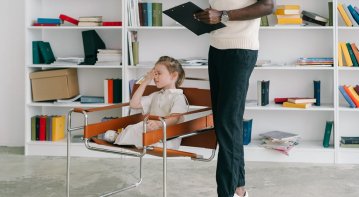 A school psychologist engaging with students in a classroom setting, promoting emotional well-being and academic growth through supportive learning activities