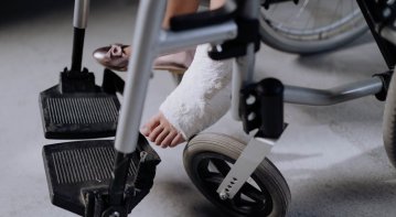 A physical therapist assists a patient recovering from a personal injury by guiding leg exercises in a rehabilitation clinic, symbolizing effective strategies for faster healing and recovery