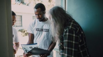 Illustration of a social worker advocating for policy change, engaging with community members and decision-makers to influence systemic reforms