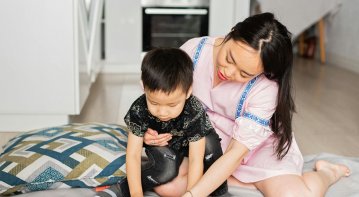 Parent observing a young child showing early signs of speech delay during playtime