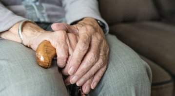 Person journaling positive affirmations in a bright, peaceful room to cultivate an uplifting mindset.