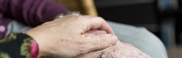 Elderly person receiving professional emotional support, sitting with a counselor in a warm, comforting environment to enhance emotional well-being.