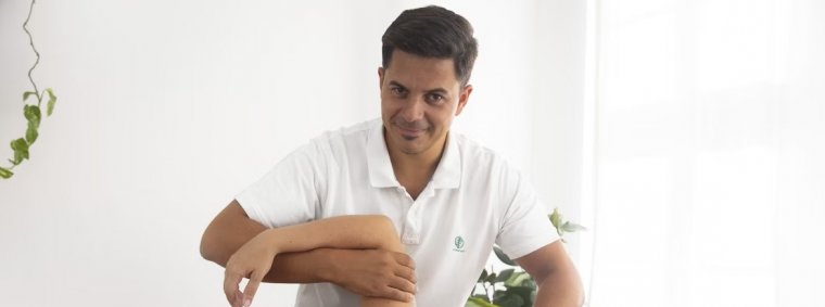 A physiotherapist guiding a patient through targeted shoulder exercises using resistance bands and manual therapy, aimed at relieving shoulder pain and improving mobility.