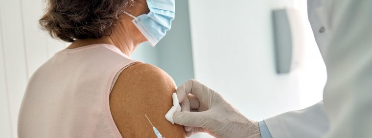 Elderly patient receiving pneumonia vaccine from a healthcare professional as part of preventive senior care