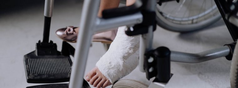 A physical therapist assists a patient recovering from a personal injury by guiding leg exercises in a rehabilitation clinic, symbolizing effective strategies for faster healing and recovery